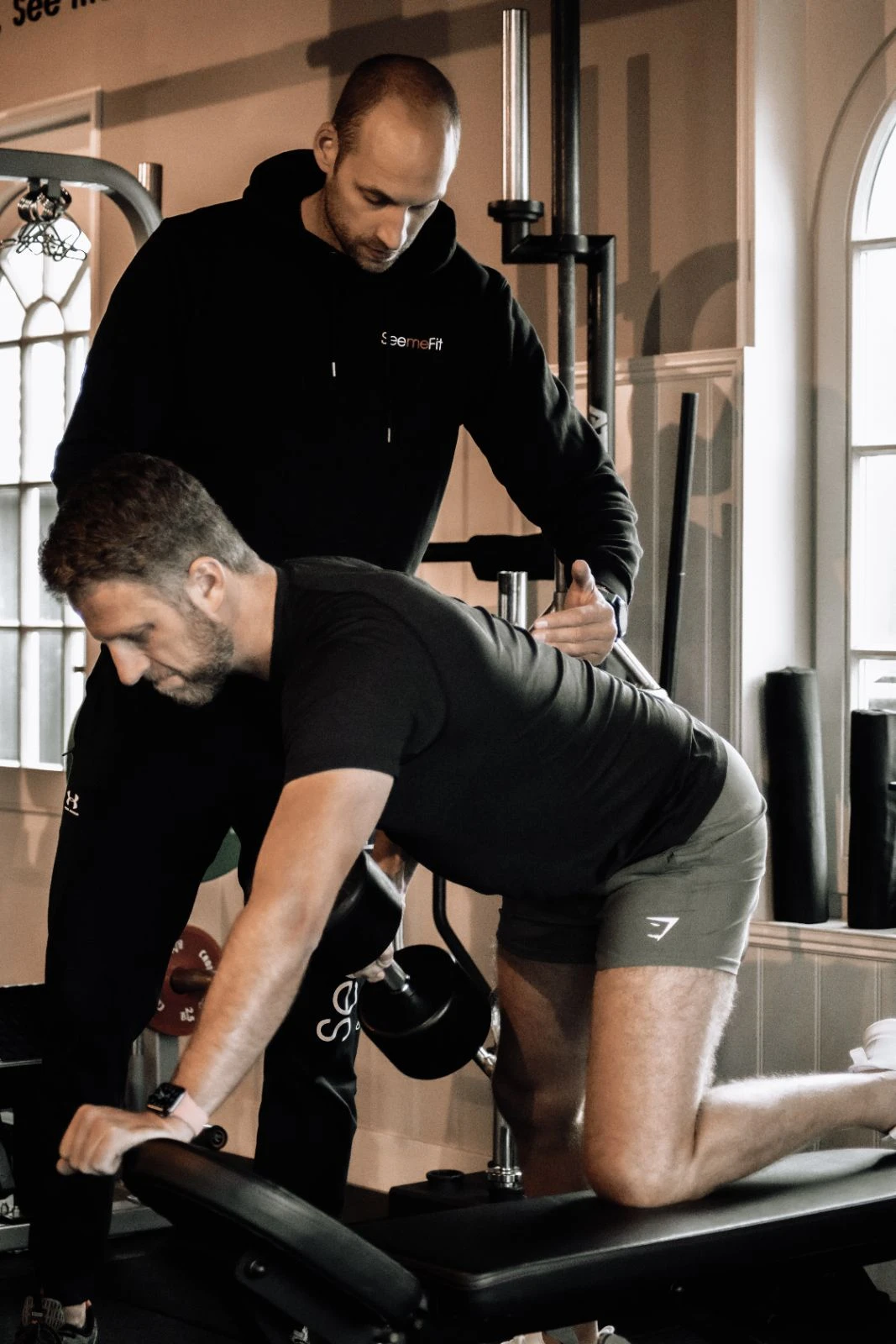 Coach corrigeert houding bij dumbbell row